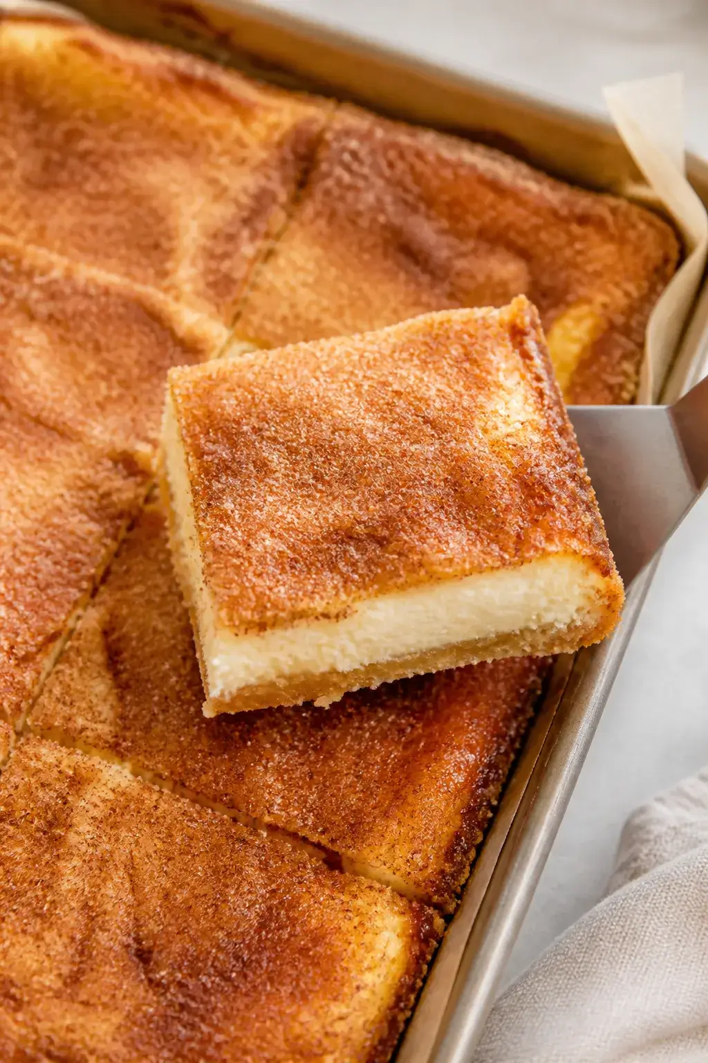 Close-up detail shot: A freshly baked pan of sopapilla cheesecake just out of the oven, showing the