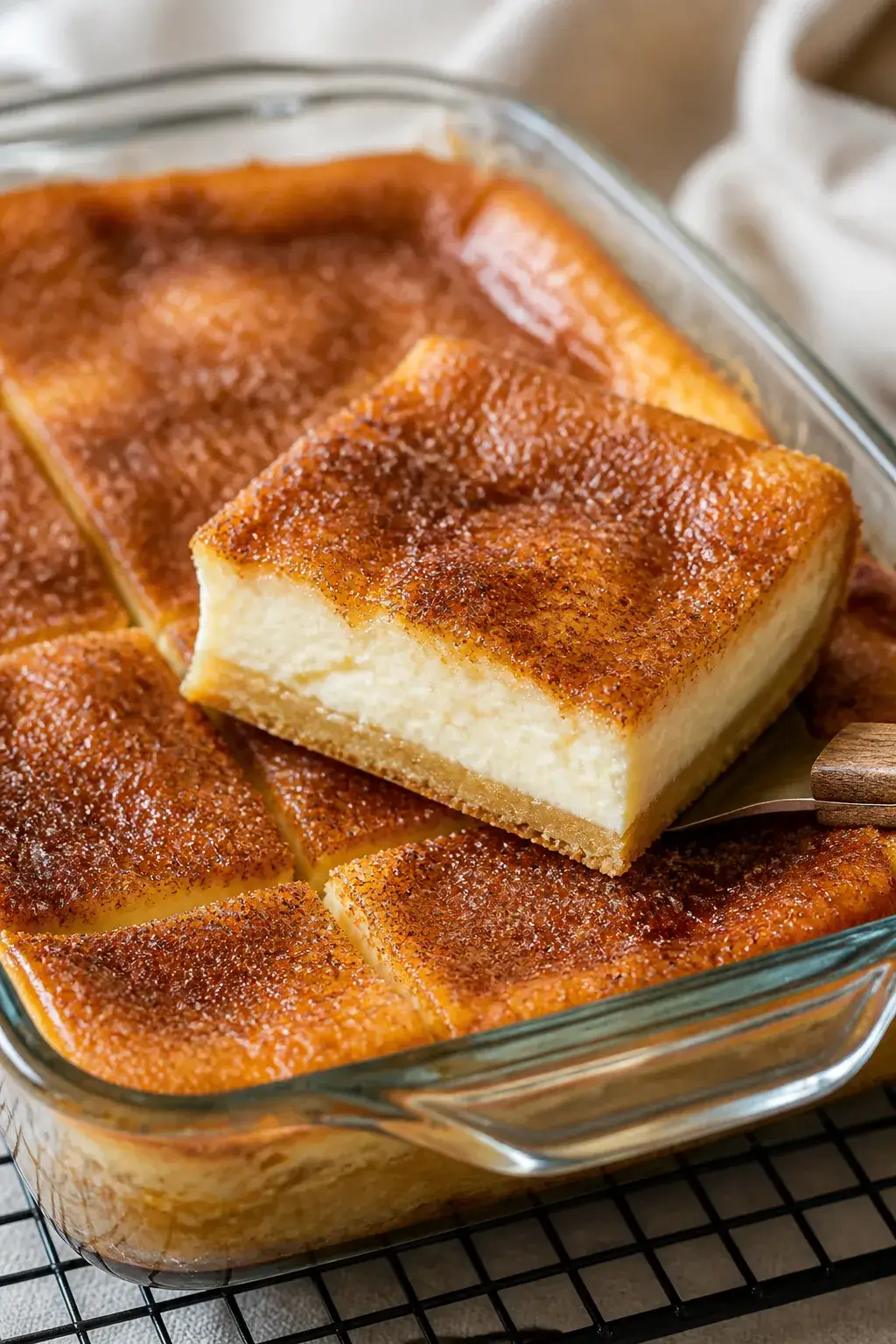 Close-up detail shot: A just-baked pan of sopapilla cheesecake in a 9x13 glass baking dish, top crus
