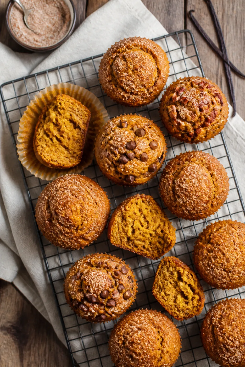 Final dish overhead presentation: Top-down shot of freshly baked pumpkin muffins on a black wire coo