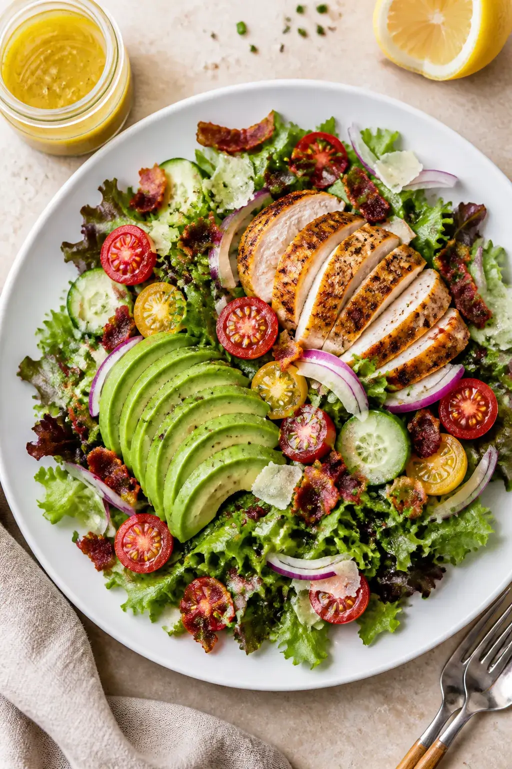 Final plated overhead: Restaurant-worthy Chicken Bacon Avocado Salad arranged on a wide, matte white