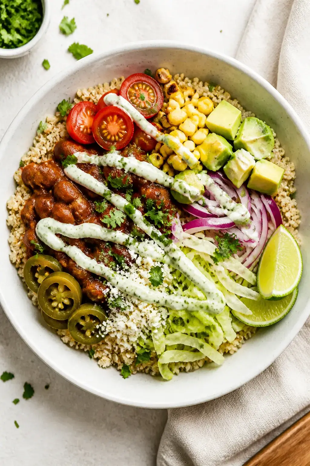 Final plated overhead: Vibrant quinoa taco bowl assembled in a wide, white ceramic bowl on a light l