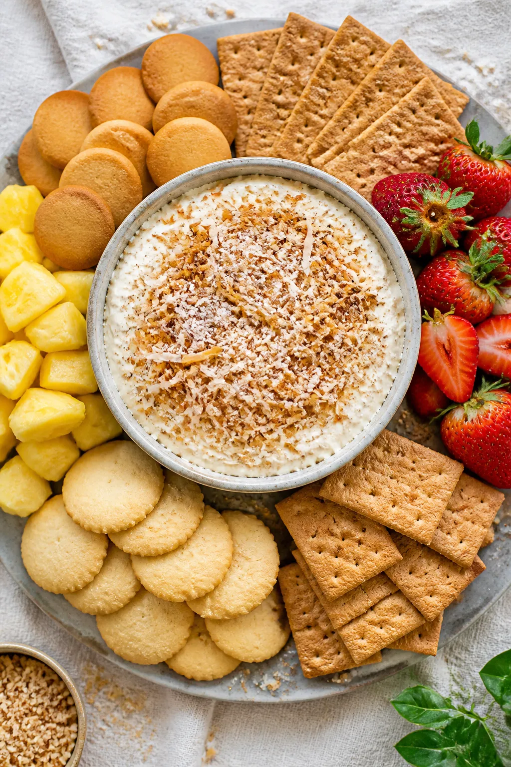 Overhead final presentation of a party-ready spread: a generous bowl of Coconut Cream Pie Dip center