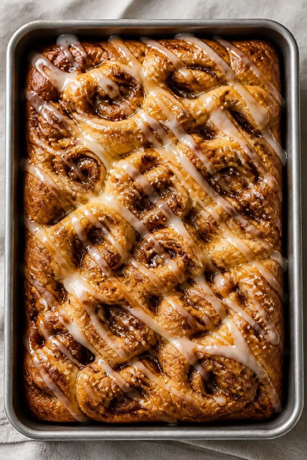 Overhead shot of cinnamon roll focaccia just out of the oven in a well-oiled 9x13 metal pan: golden 